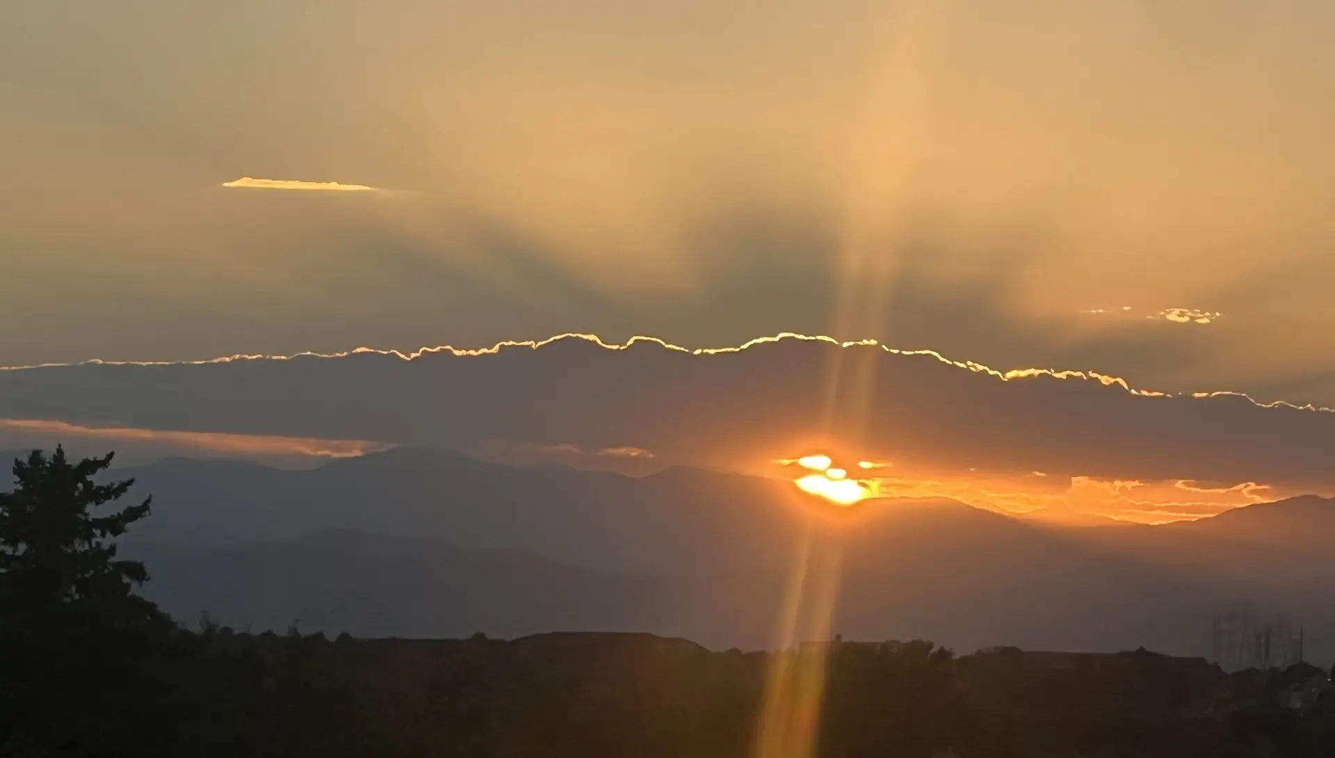 sunset-over-mountains-with-sun-rays-through-clouds